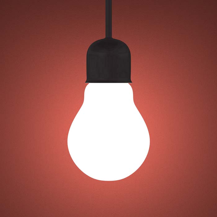 Lit lightbulb on dark red-orange background