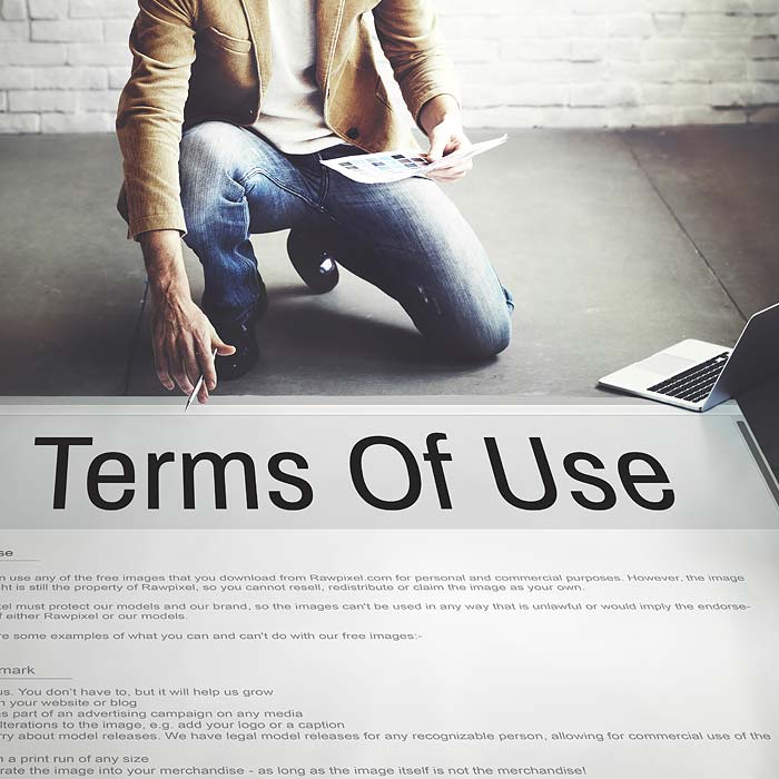 Man bent down looking at terms of use poster on floor