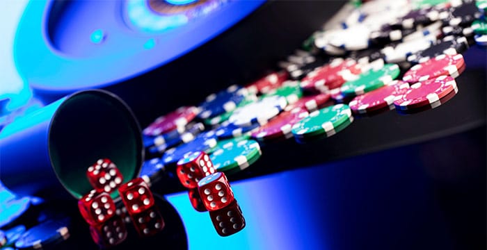 High contrast image of casino roulette, poker chips, dice.